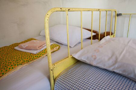 Furniture details of old and clean beds with pillows, part of old vintage style household room.の写真素材