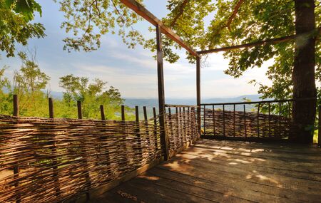Being on an old wooden balcony in forest, during sunny summer day.の写真素材
