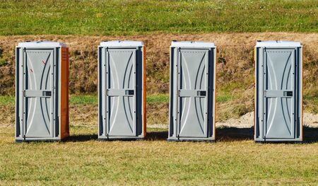 Four toilets on green field during sunny day.の写真素材