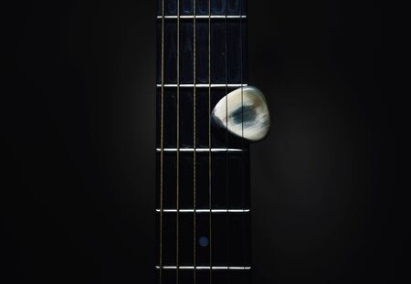 Details of an old acoustic guitar, Django style, closeup view of neck and handmade pick.の写真素材