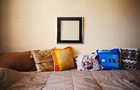 Lifestyle details, colorful pillows and empty frame.の写真素材