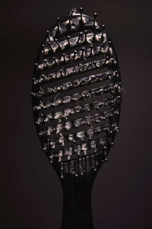 Closeup view of old dirty and used hairbrush with dirt and hairs on it.の写真素材