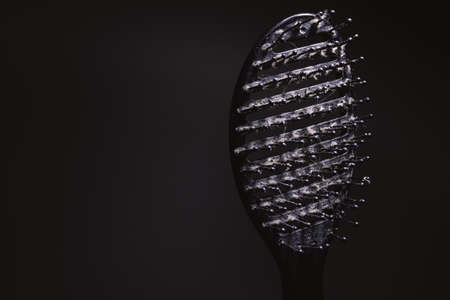 Closeup view of old dirty and used hairbrush with dirt and hairs on it.の写真素材