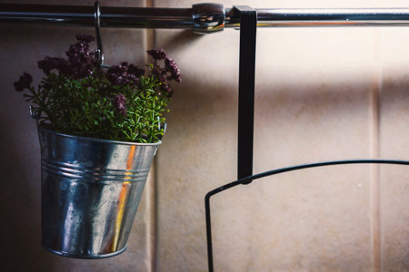 Decorative flowers in a metal bucket hanging on a bar in the kitchen, as a decoration and fragrant detail.の写真素材