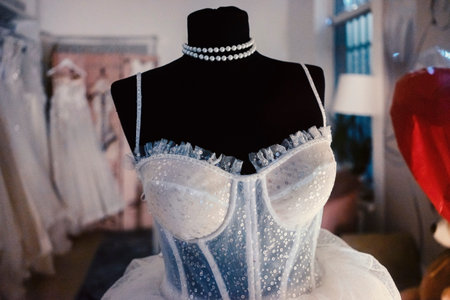 Showcase of a wedding dress salon, white modern wedding dress on a black mannequin.