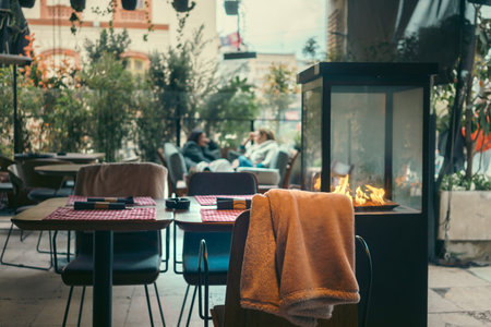 Table and chairs with a heating cabinet in an outdoor cafe.の写真素材