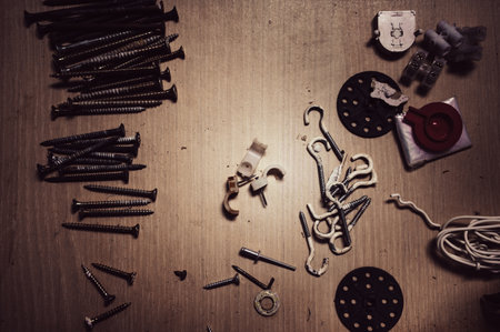 Used screws and hooks on a wooden table. Accessories for crafts.の写真素材