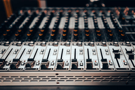 Modern audio mixer control panel with faders and buttons.の写真素材