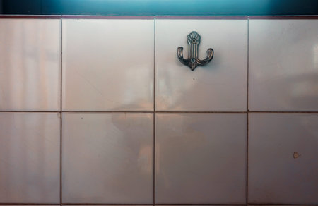 Metal hanger on wall ceramic tiles. Lifestyle details.