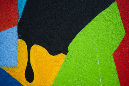 The texture of a wall painted in various colorful figures.