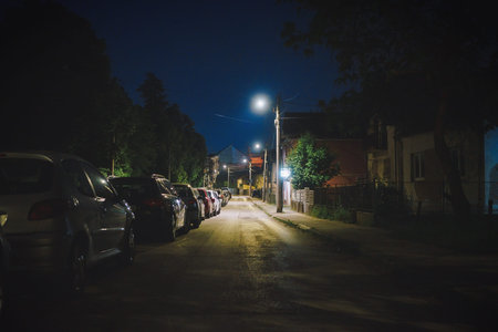 Night street scene in Balkan town, parked cars, no people, details of street lighting.の写真素材
