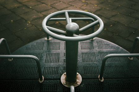 Details of a metal carousel in a park, outside on a rainy day.の写真素材