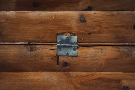 Texture of a wooden wall made of old boards with a metal hinge in the middle.の写真素材