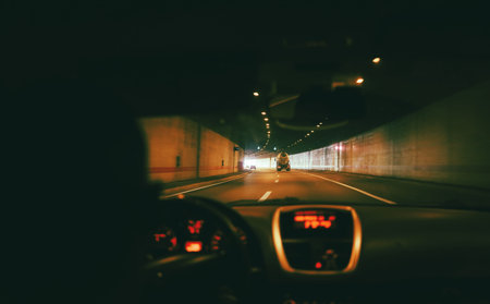 Driving a car through a tunnel, a big truck nearby.