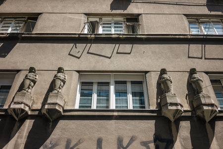 Decorative statues by the windows of the old building, seen from below.の写真素材