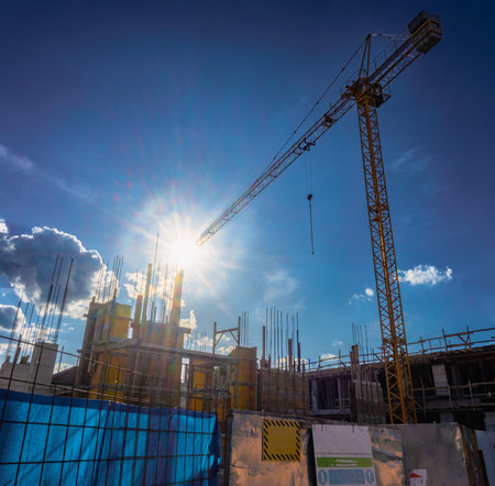 Details from the construction site, large crane and wooden formwork in place, sky in the background,...