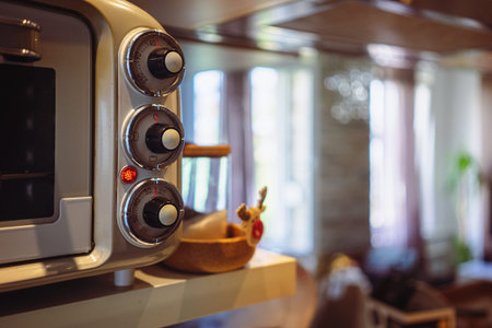 Switches on old vintage oven in apartment close up, room in background.の写真素材