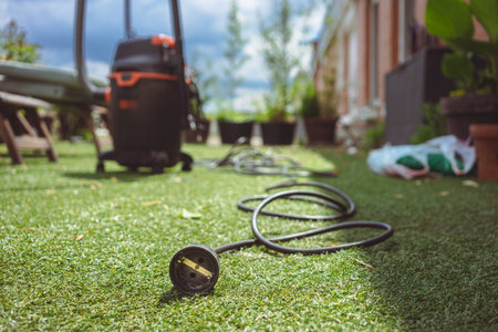 Vacuum cleaner on terrace, artificial grass with focus on cable outlet.の写真素材