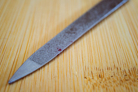 Nail file on a wooden table, macro composition of the tip of the file.の写真素材