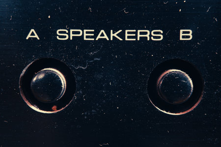 Buttons for A Speakers B on hi-fi device, dusty surface.