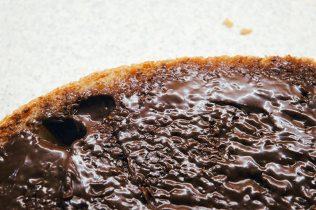 Chocolate cream on a slice of bread, macro view.