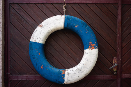 An old ship's lifebuoy on a wooden door as decoration.の写真素材