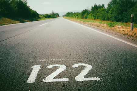 Number 122 written in white paint on the road, close-up view, daytime.の写真素材