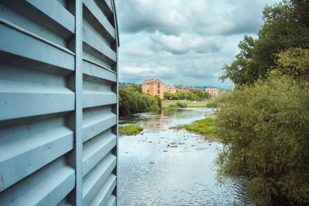 Life by the river, landscape of the river with buildings in the distance, summer season. Cacak town,...