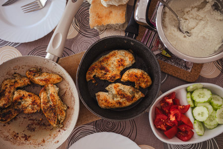 Chicken in a pan, prepared at home, placed on the table with vegetables.の写真素材