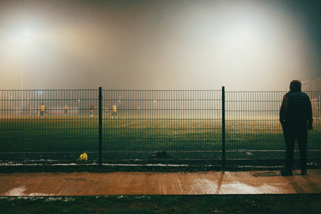 Night scene of soccer fields with players in autumn, foggy atmosphere.の写真素材