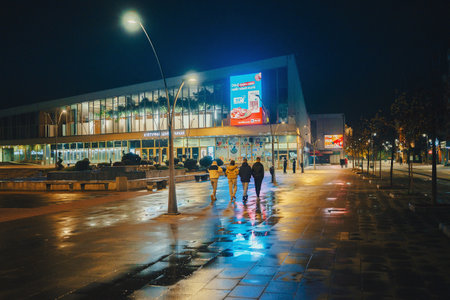 Cacak, Serbia - November 23, 2025: City center at night, rainy and cold weather. Details of main streets with promenade.のeditorial素材