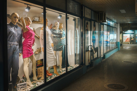 Cacak, Serbia - December 09, 2025: Women's clothing fashion store in the city center, night scene in one of the aisles.のeditorial素材