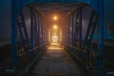 Night scene of pedestrian bridge in foggy atmosphere, city of Cacak in Serbia, late autumn.