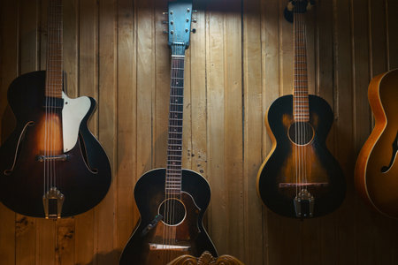 Old acoustic guitar from the 60s, close-up view, paneling in the background.の写真素材