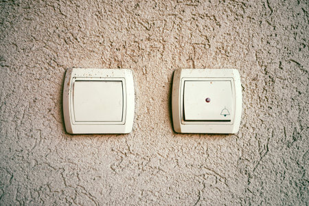 Bell and light buttons on the wall of the house, close-up view.の写真素材