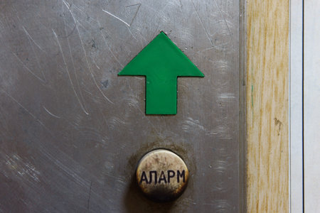 Plastic green up arrow and burnt button with the inscription Alarm in Cyrillic, details of an old...