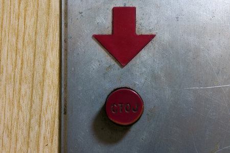 Plastic red down arrow and stop button in Cyrillic, details of an old elevator.