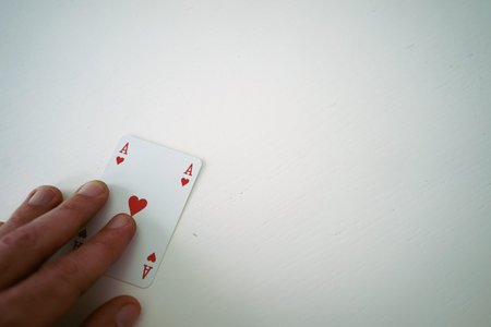 Card ace heart under hand on white table.の写真素材