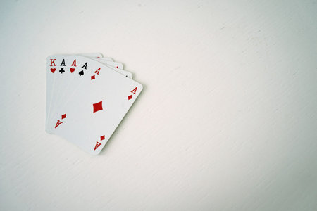 Playing poker, four aces and a king on the white table, plenty of copy space.の写真素材