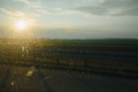 View from the back seat of a car through a dirty window, glass details and blurred nature...