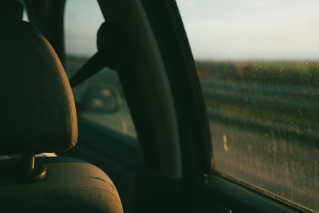 View from the back seat of a car through a dirty window, glass details and blurred nature background.の写真素材