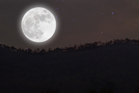 Full moon with stars over mountain on darkness sky.の写真素材