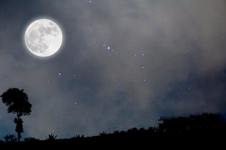 Full moon in starry night over village.の写真素材