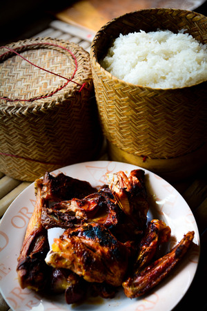 Grilled chicken on plate on bamboo background and sticky riceの写真素材