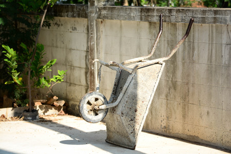 Construction wheelbarrow leaning against the wallの写真素材