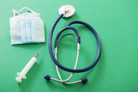 medical mask and stethoscope on green backgroundの写真素材