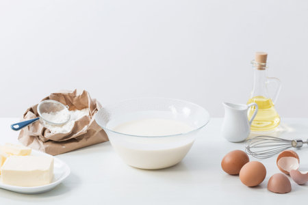 dough in glass plate and products for its preparation on  white background