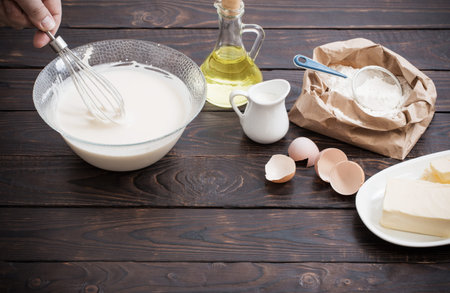 dough  and products for its preparation on  dark wooden background