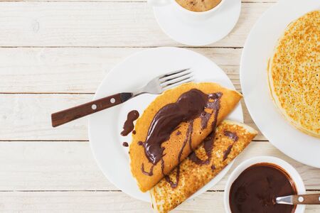 pancakes with chocolate and coffee on white wooden backgroundの写真素材