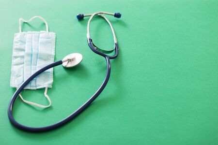 medical mask and stethoscope on green backgroundの写真素材